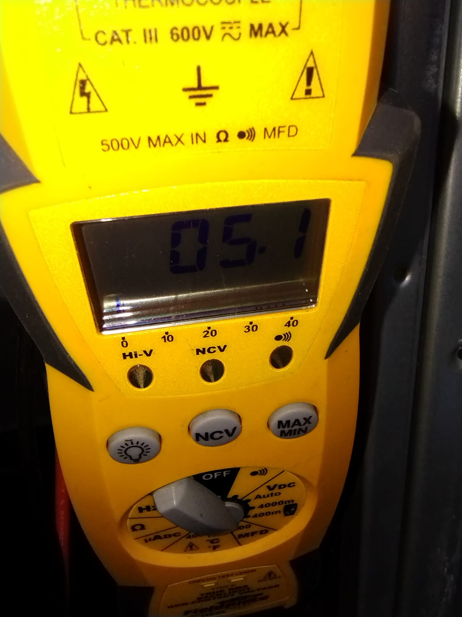 HEP technician using a digital multimeter during diagnosis